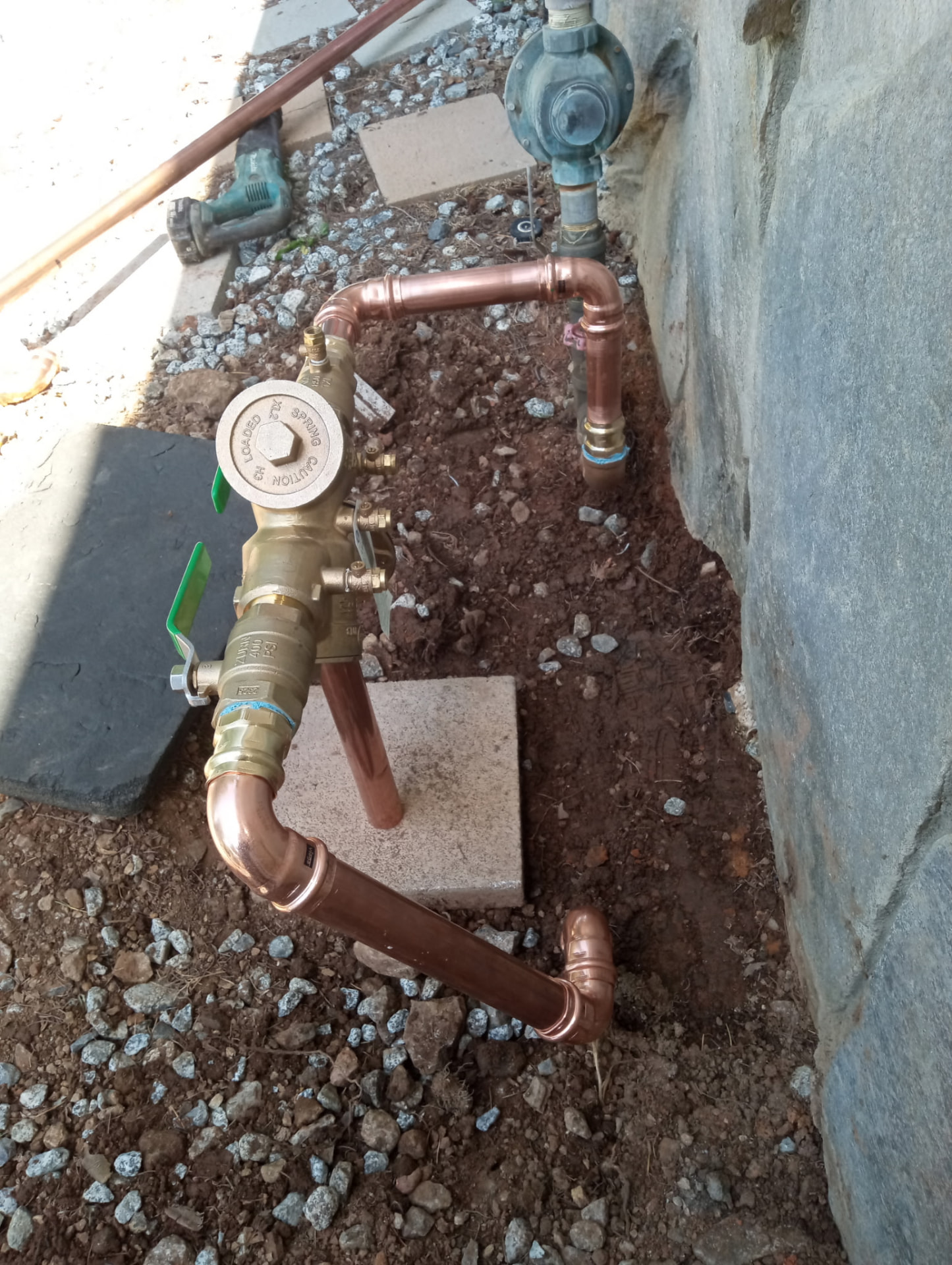 Brass backflow prevention assembly connected to copper piping
